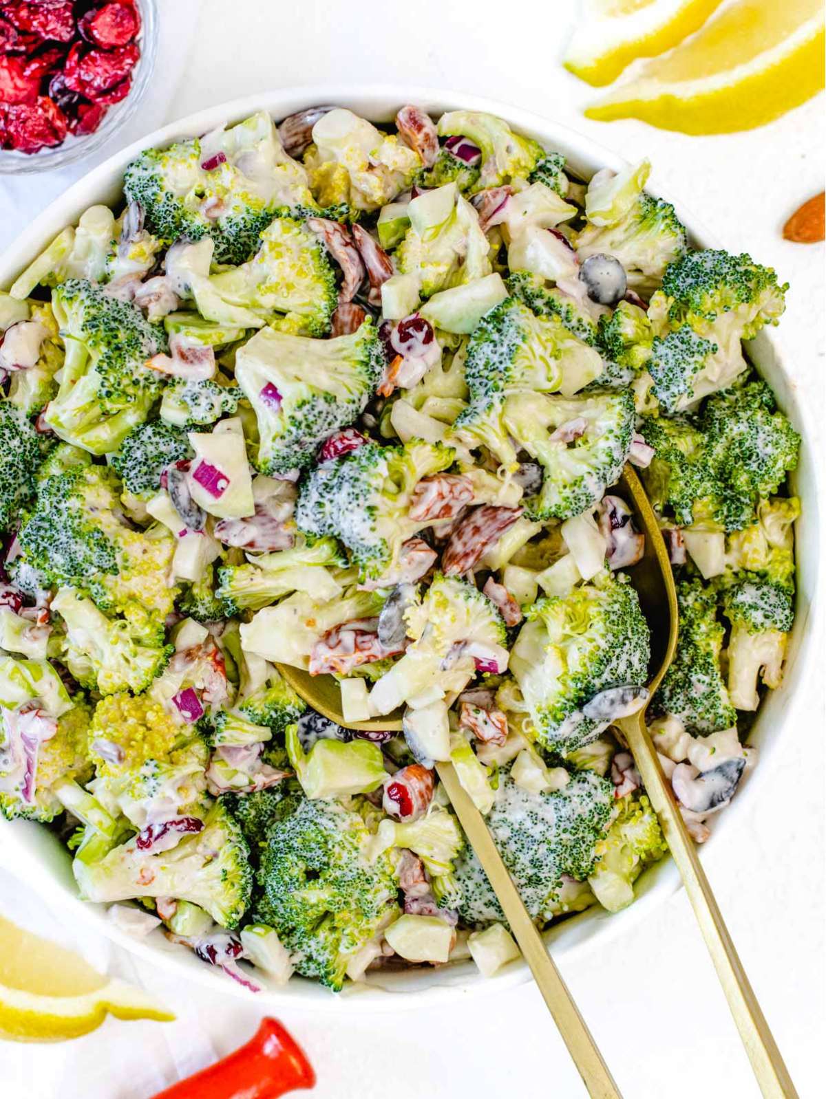 Top down healthy broccoli salad with sun dried tomatoes nuts and yogurt dressing.