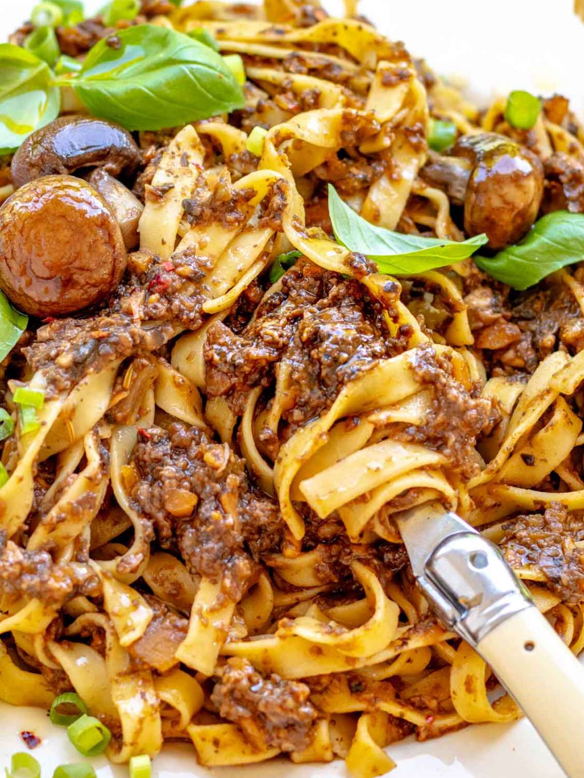 Close up Mediterranean mushroom pasta easy and protein rich with basil and olive oil.