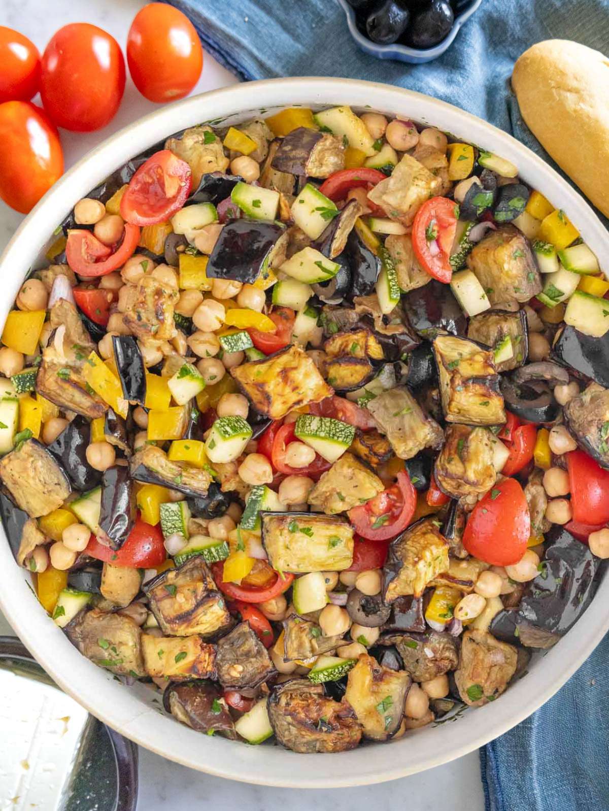 Close up chickpea eggplant salad with marinated chickpeas zucchini and fresh herbs.
