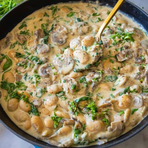 Creamy Marsala butter beans with mushrooms and spinach served in a skillet for dinner.