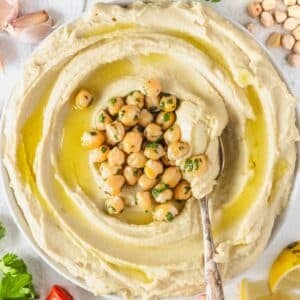 Easy hummus recipe with canned chickpeas served with pita bread and olive oil.