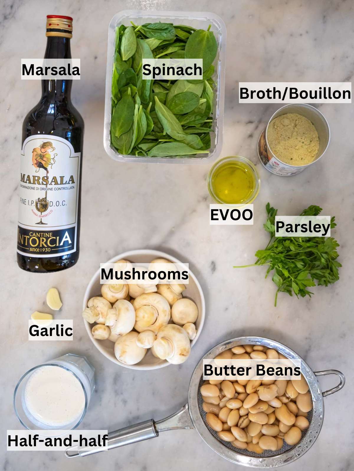 Fresh butter beans mushrooms spinach parsley Marsala wine and half and half arranged on kitchen counter.
