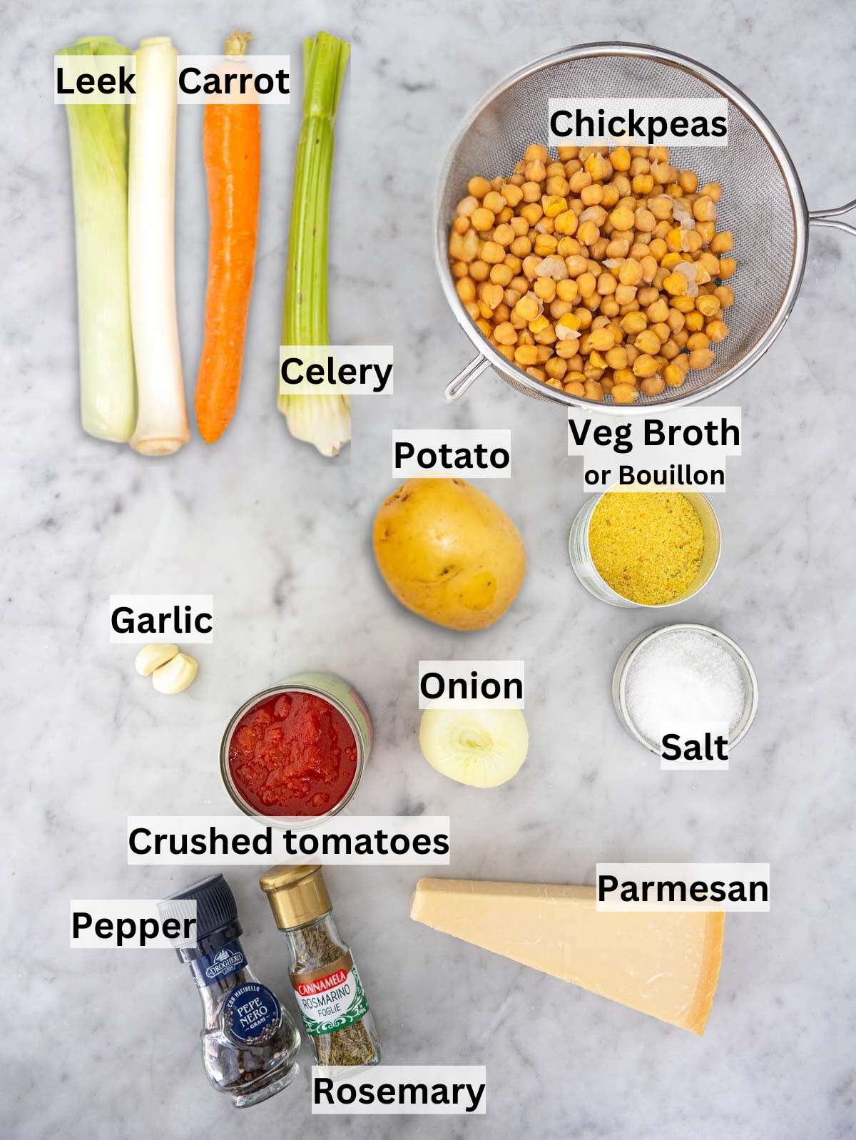 Fresh ingredients for Mediterranean chickpea soup including chickpeas potatoes tomatoes and vegetables on marble table.