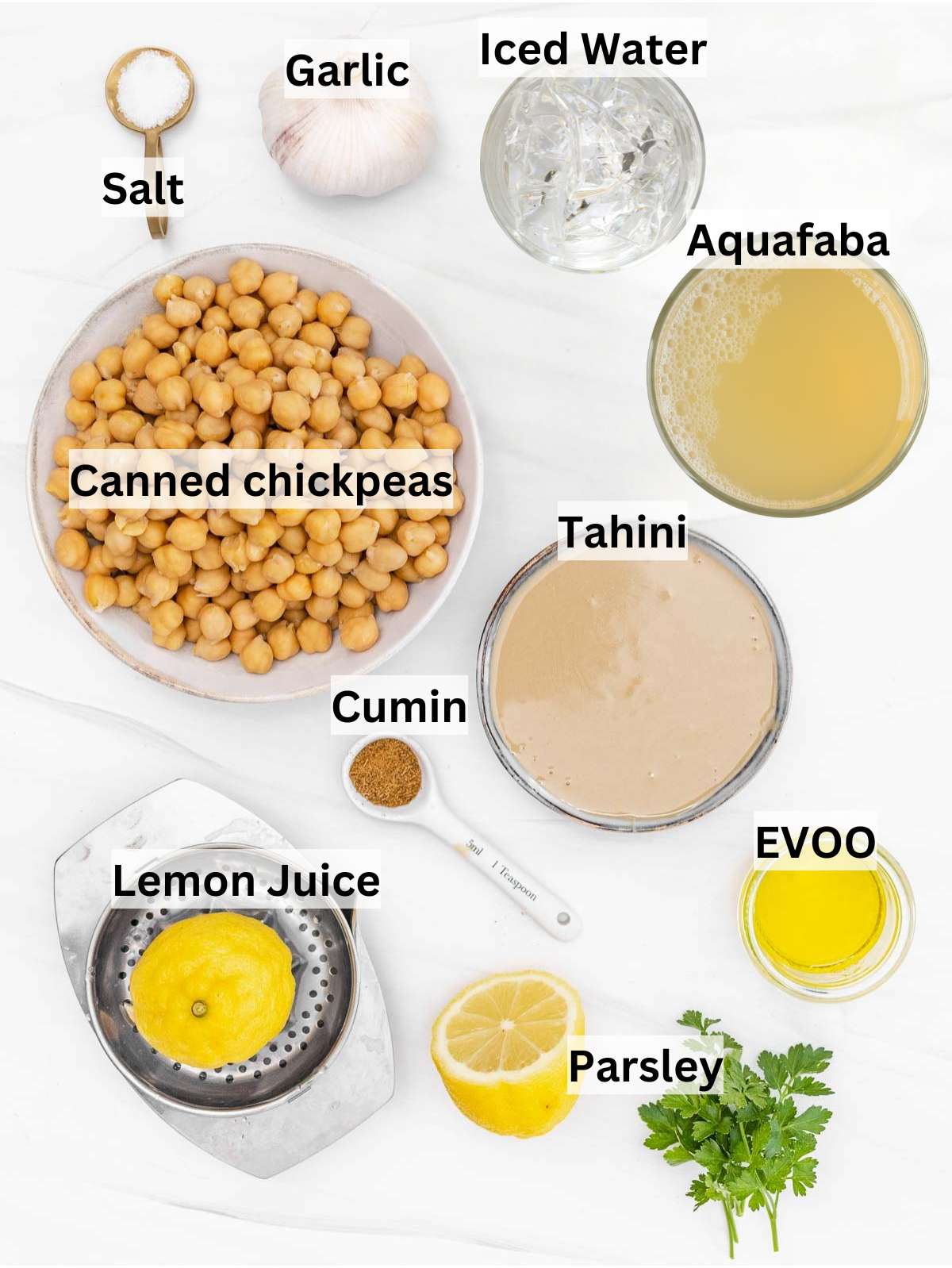 Ingredients for hummus recipe with canned chickpeas tahini lemon garlic parsley olive oil displayed together.
