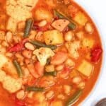 Rustic bowl of healthy vegetable soup with beans cauliflower and green beans.