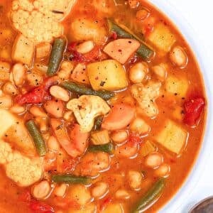 Rustic bowl of healthy vegetable soup with beans cauliflower and green beans.