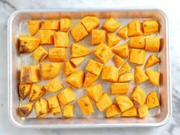 Step 1 Cubed sweet potatoes on baking tray roasted for Mediterranean lentil salad.