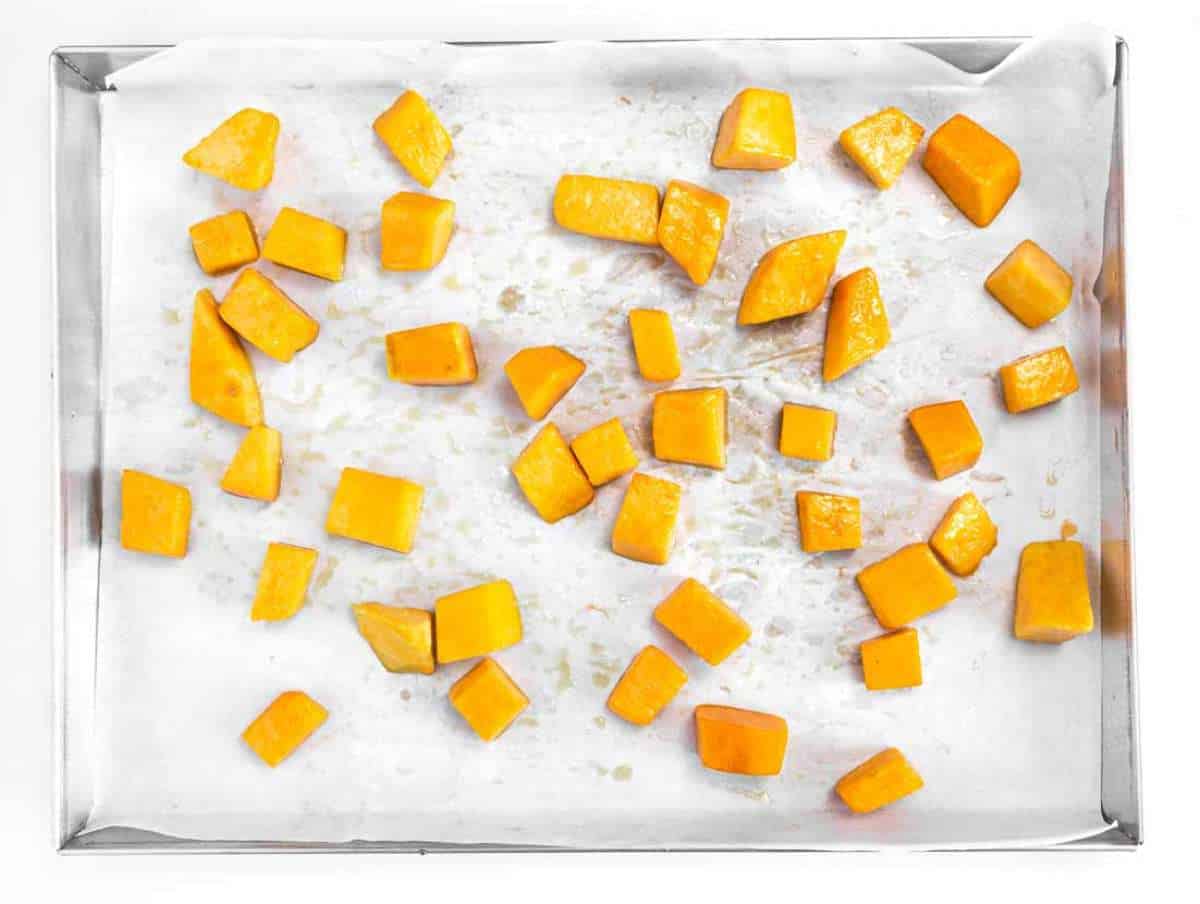 Step 1 Cubes of butternut squash roasting on a baking tray until tender and golden.