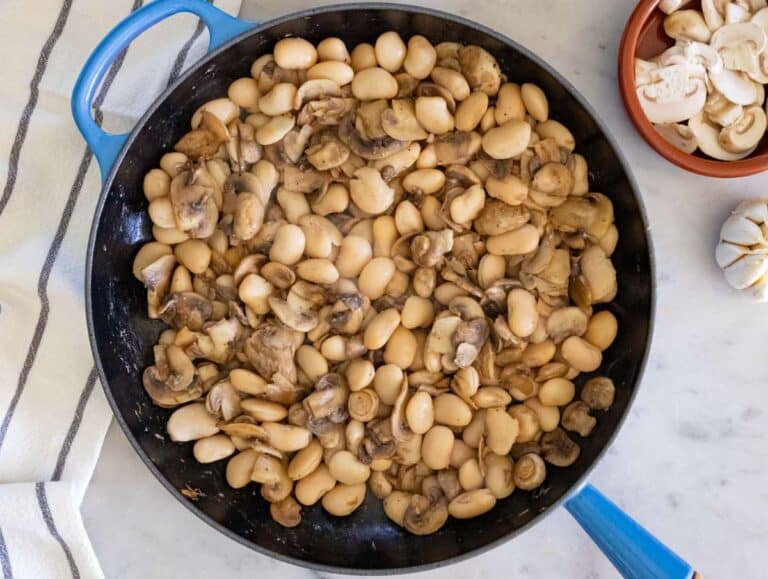 Step 2 Adding butter beans to skillet with mushrooms for rich vegetarian marsala recipe base.