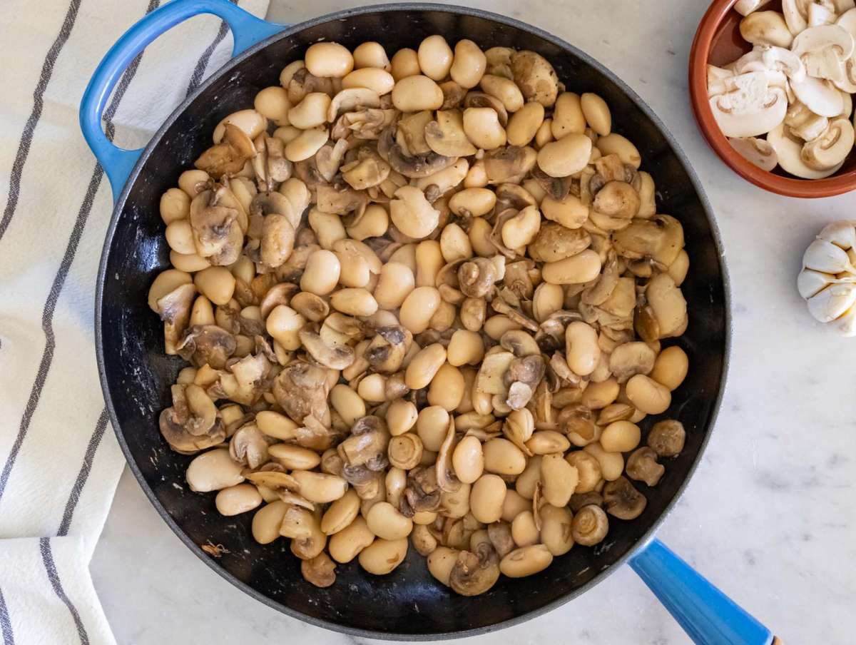 Step 2 Adding butter beans to skillet with mushrooms for rich vegetarian marsala recipe base.