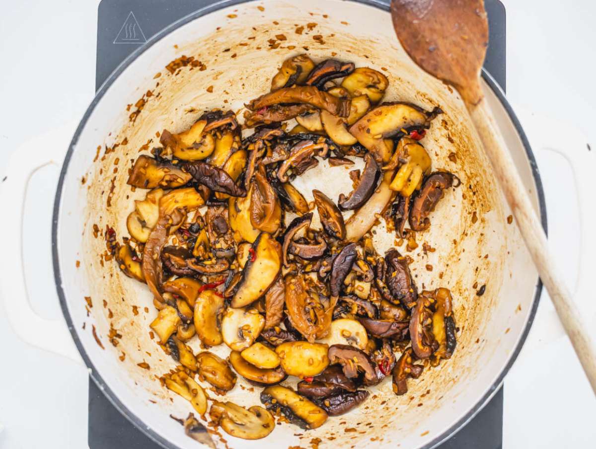 Step 2 Cooking garlic ginger and mushrooms in a pot for flavorful tofu mushroom soup base.