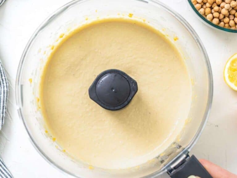 Step 1 Tahini cumin and cold water added to chickpea mix for smooth creamy hummus texture.