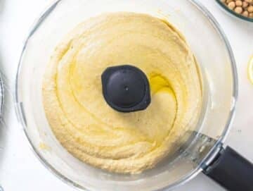 Step 2 Olive oil drizzled into hummus mixture blending to silky creamy consistency in food processor.