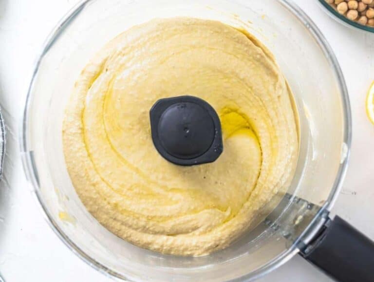 Step 2 Olive oil drizzled into hummus mixture blending to silky creamy consistency in food processor.