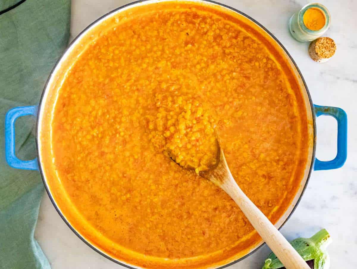 Step 3 Red lentils simmering with vegetable broth and tomatoes creating a creamy curry base.