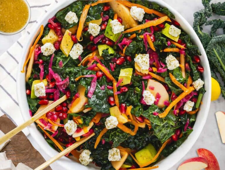 Step 4 Tossing Mediterranean kale salad with feta apple avocado and homemade dressing before serving.