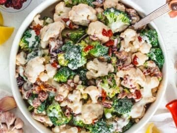 Step 4 Tossing healthy broccoli cauliflower salad with creamy Greek yogurt dressing before chilling.