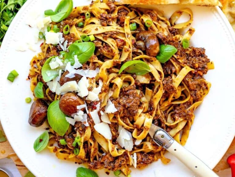 Step 5 Mediterranean mushroom pasta served on a plate with fresh basil and parmesan.