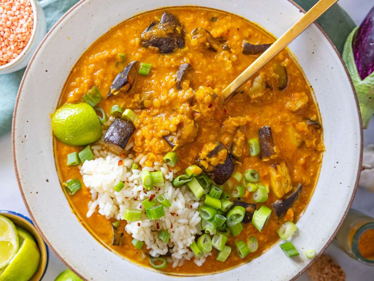 Step 5 lentil eggplant curry served hot with lime wedges and rice.