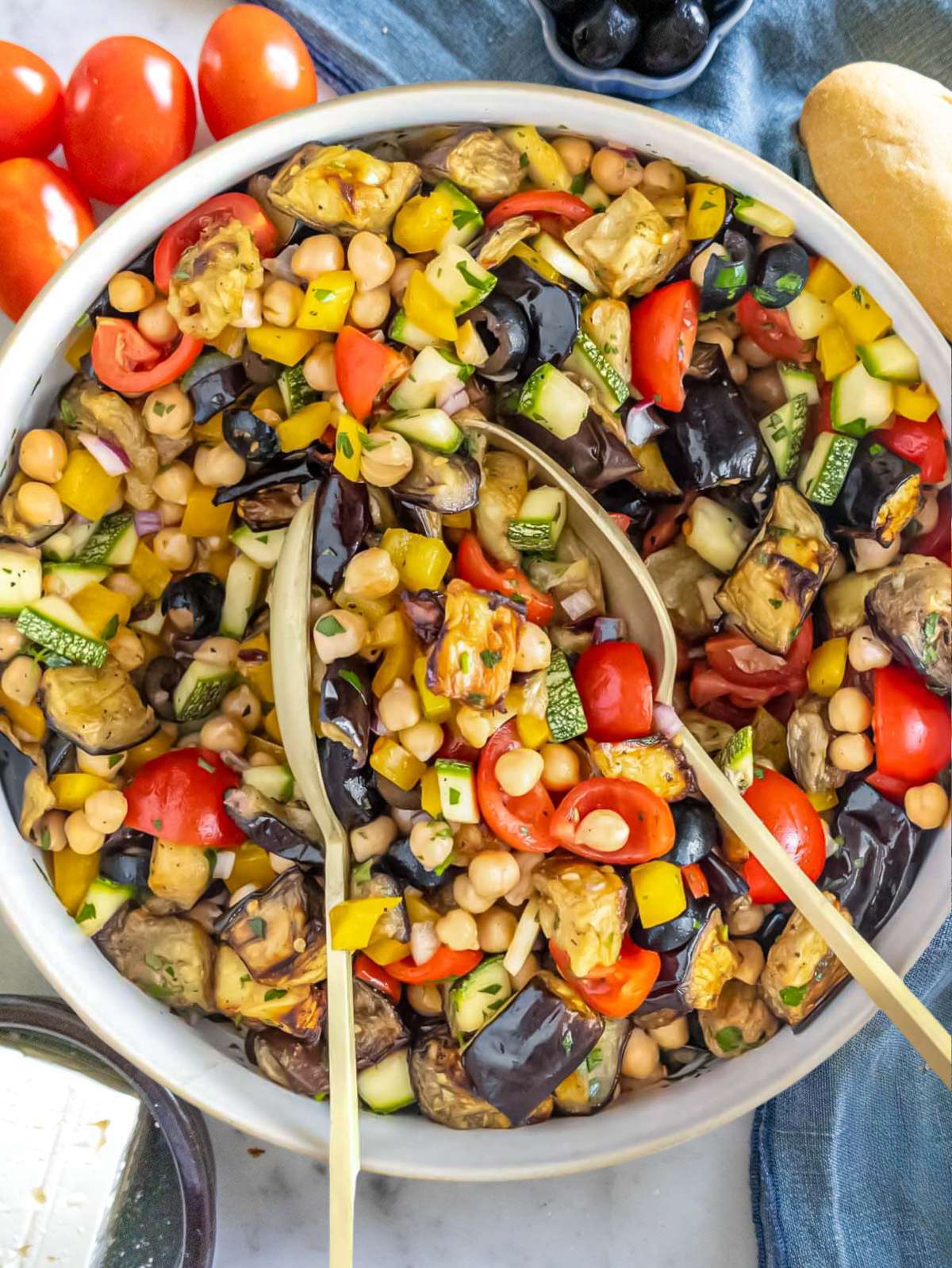 Top down view of Mediterranean chickpea eggplant salad with colorful vegetables and olives.