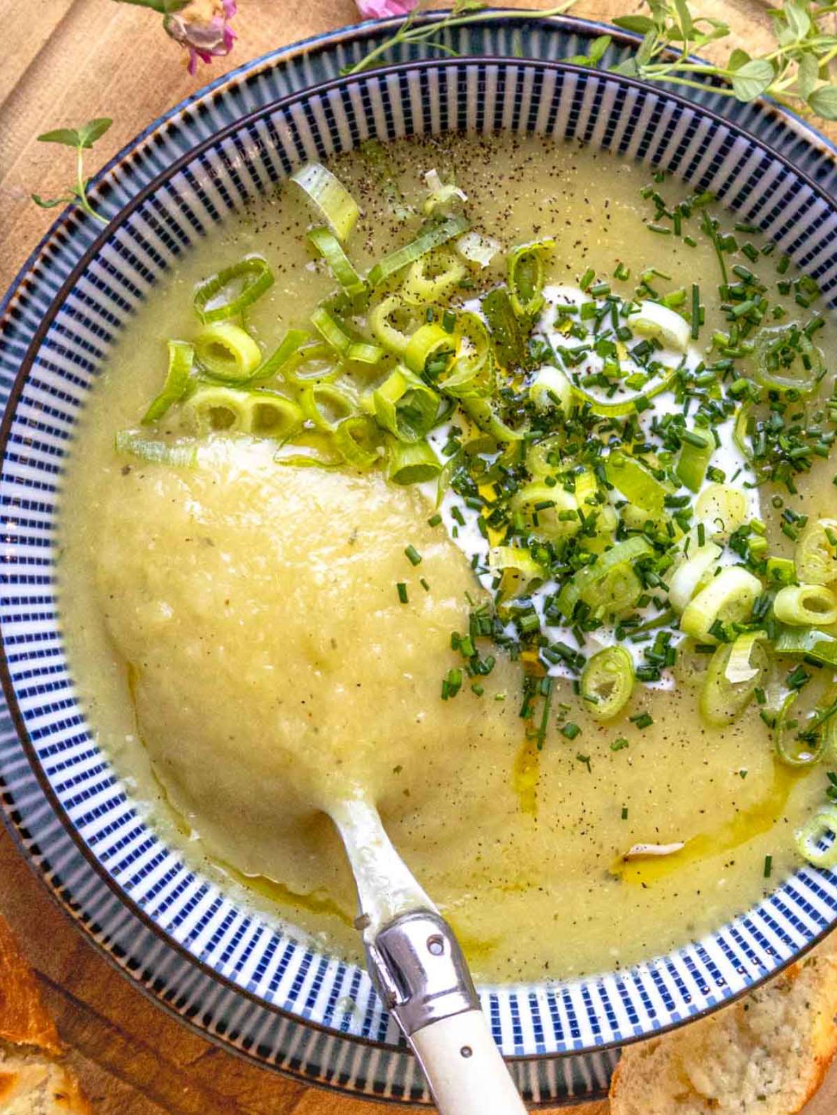 Top down view of creamy potato soup garnished with chives and Greek yogurt.