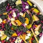 Vibrant butternut squash kale salad with apple walnuts feta and pomegranate seeds.