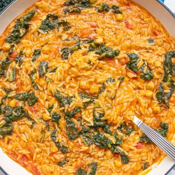 Warm Tuscan Orzo with Chickpeas and Kale in a rustic cast-iron skillet.