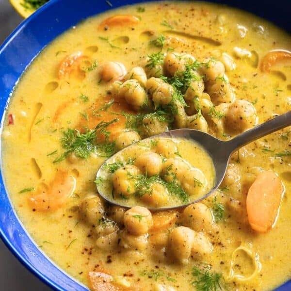 Bowl of Greek chickpea soup for blog post featuring creamy chickpeas and fresh herbs.