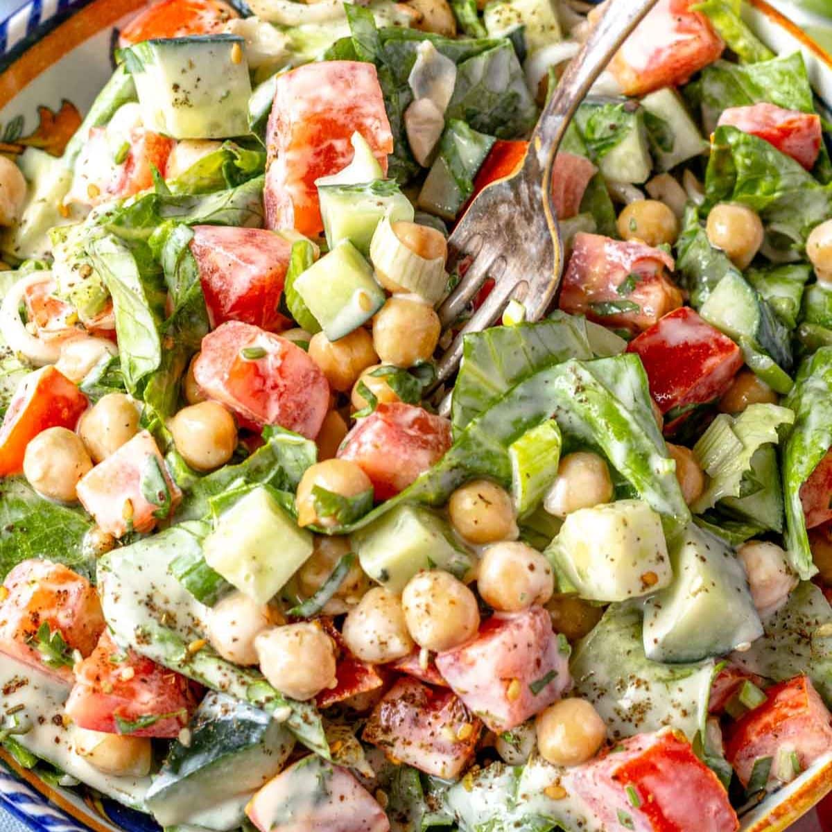 Chopped chickpea salad with healthy creamy tahini dressing served as a wholesome lunch idea.
