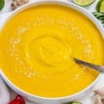 Cozy fall dinner with creamy coconut pumpkin soup in a rustic kitchen setting.