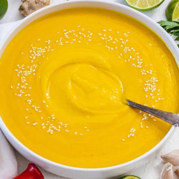 Cozy fall dinner with creamy coconut pumpkin soup in a rustic kitchen setting.