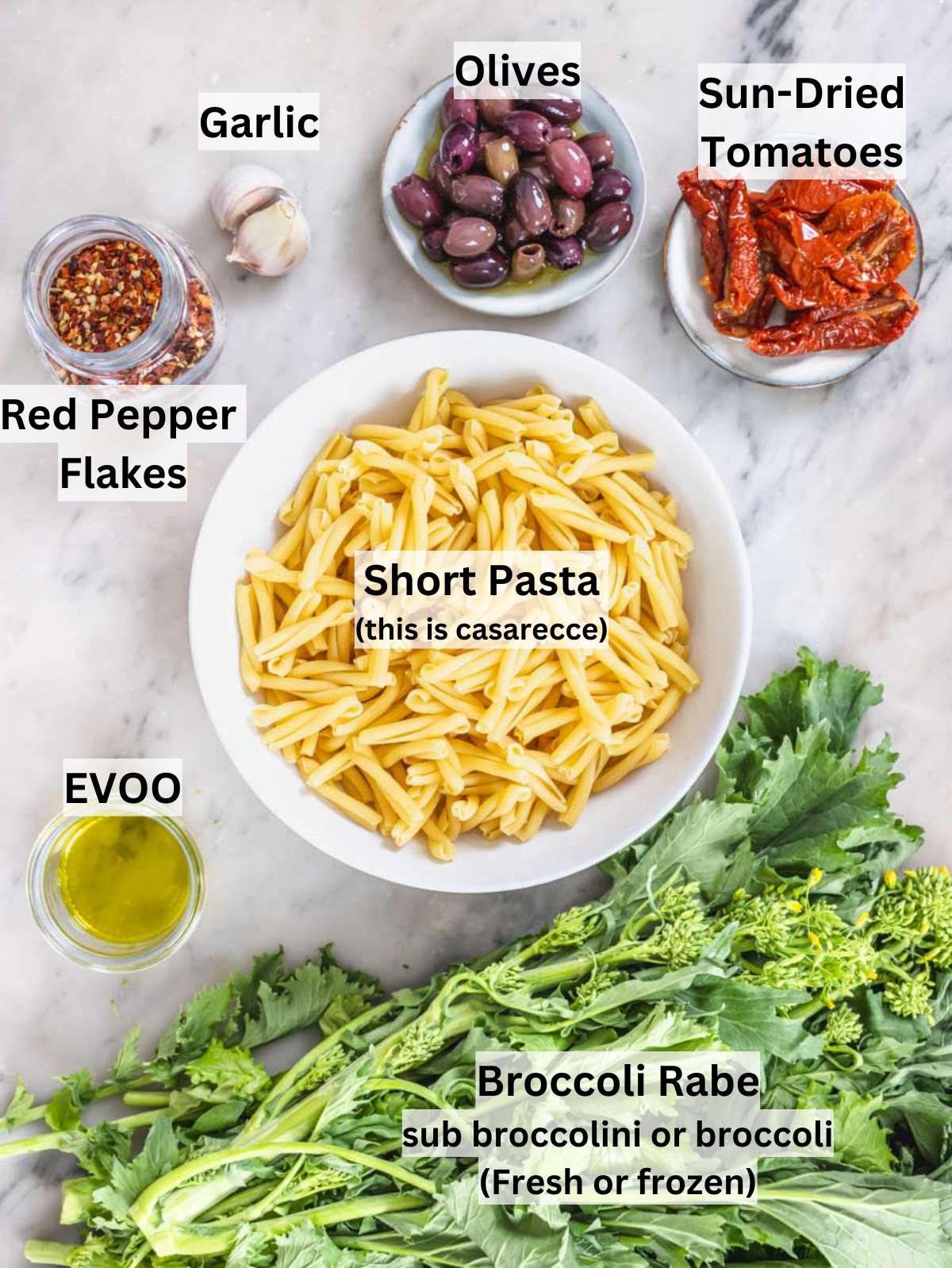 Fresh ingredients for Mediterranean pasta including broccoli rabe olives sun-dried tomatoes and feta cheese.