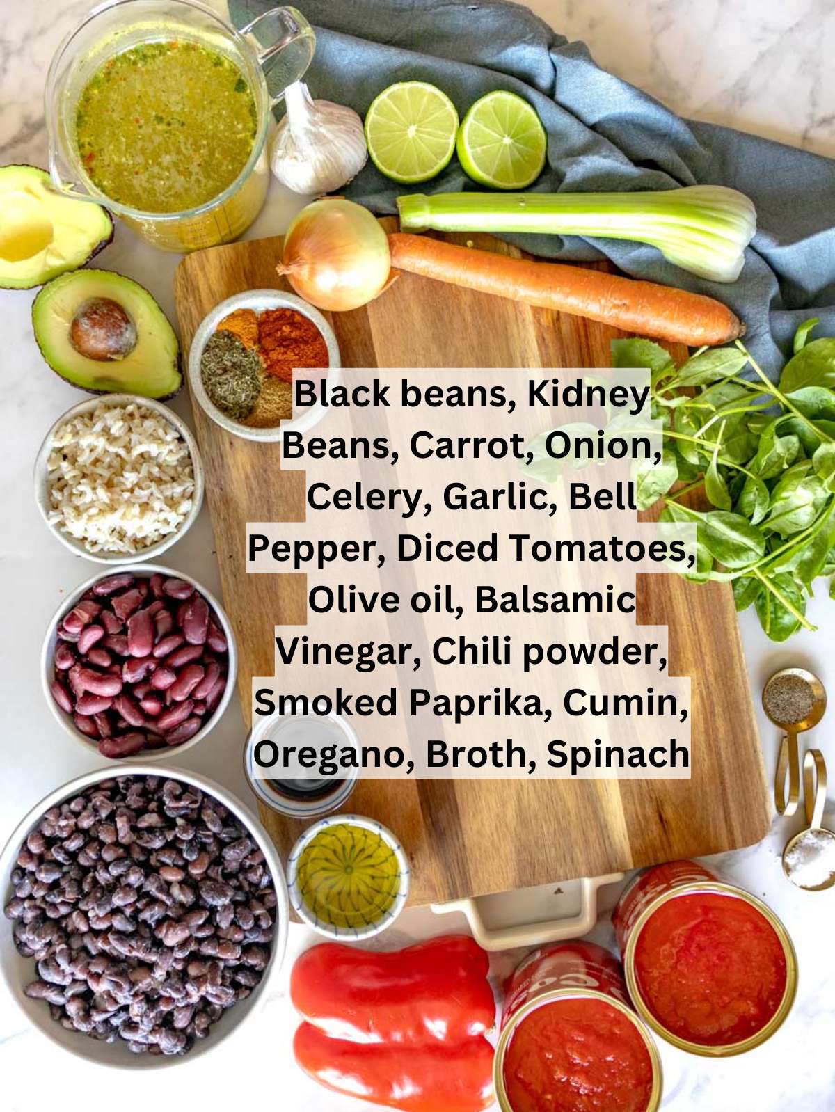 Fresh ingredients for chili with beans including beans tomatoes vegetables and spices arranged on a table.