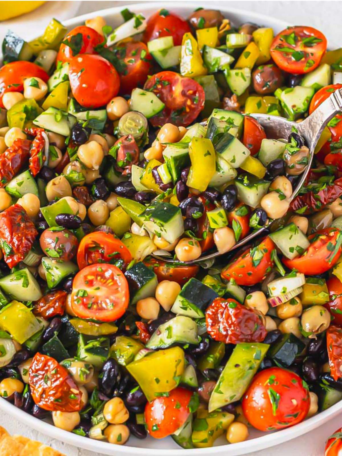 Front view of Mediterranean bean salad with beans, tomatoes, and olives mixed together.