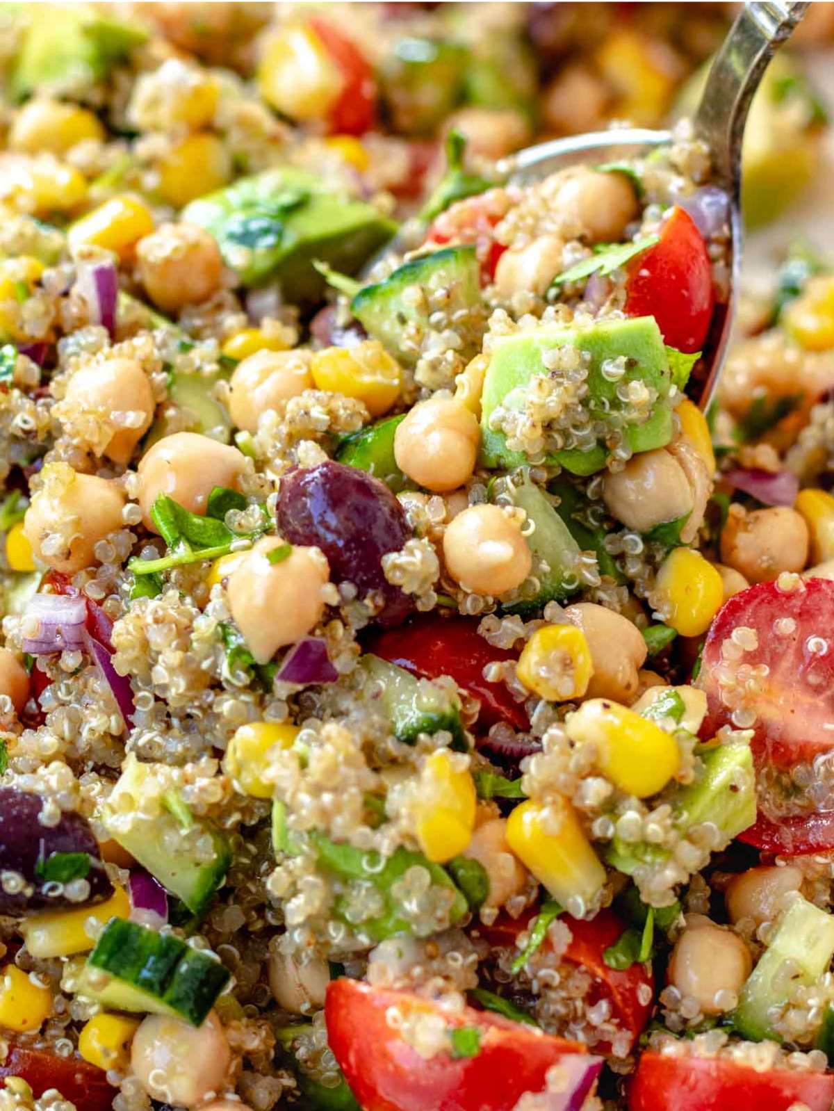 Mediterranean quinoa salad close up showing colorful veggies and chickpeas in a fresh bowl.