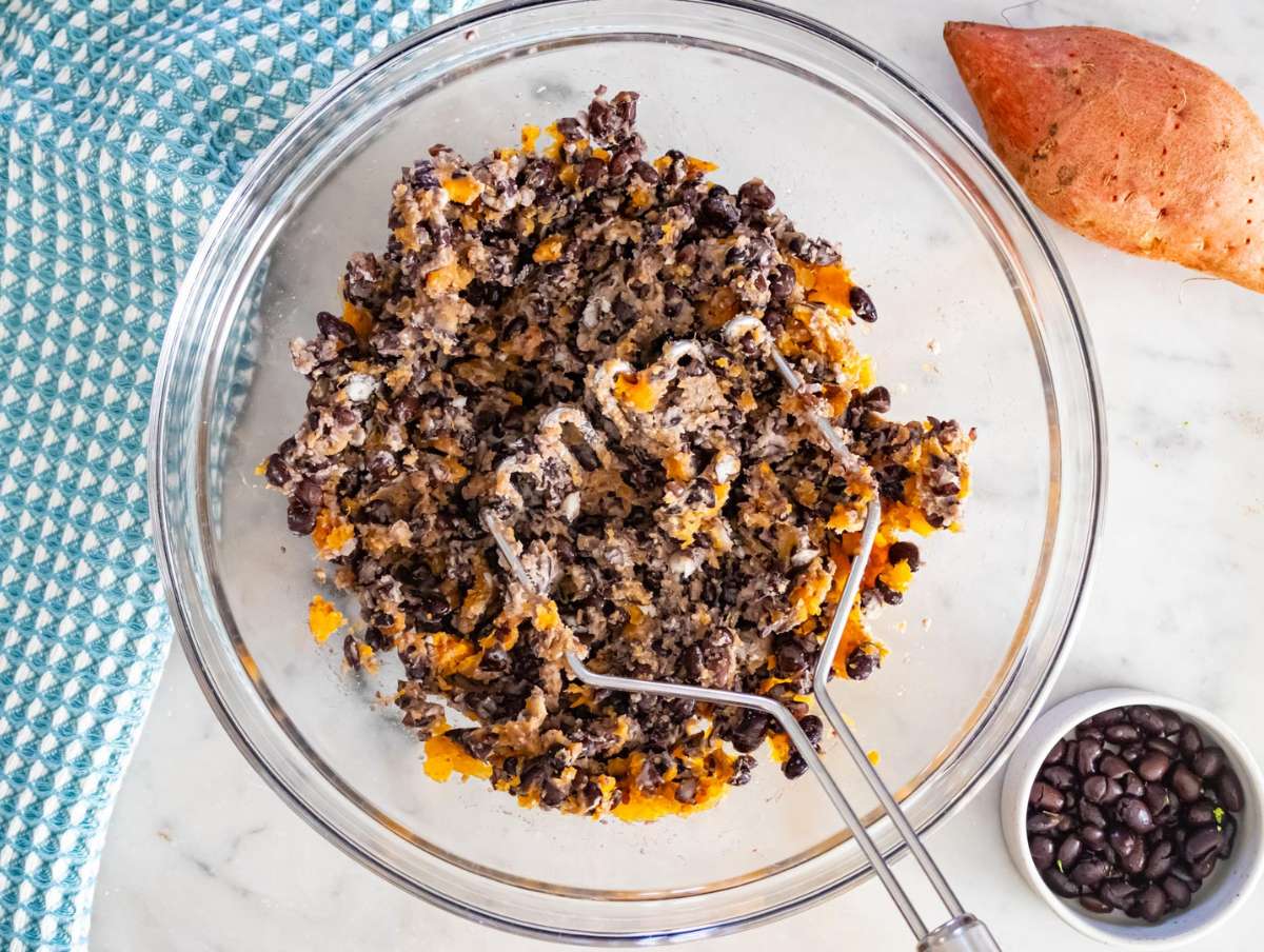 Step 1 Mashing sweet potato and black beans together in a large bowl for fritter mixture.