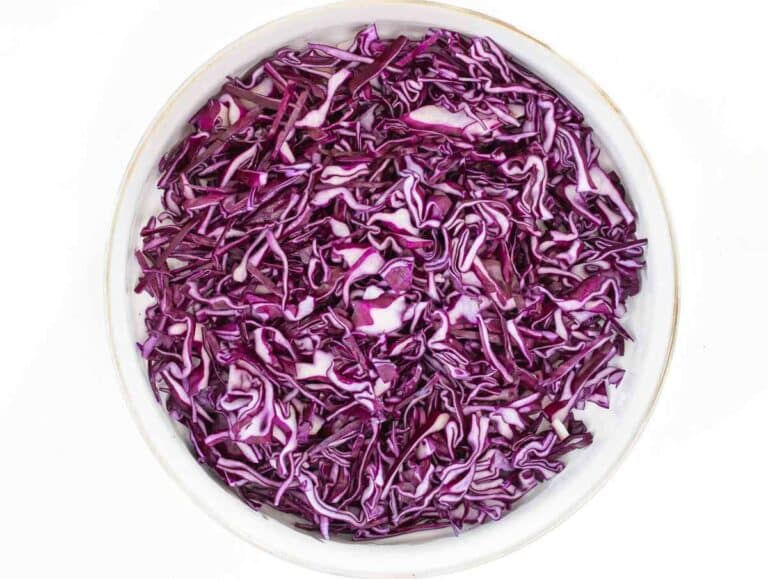 Step 1 Thinly sliced red cabbage in a bowl ready for Greek Yogurt Cabbage Slaw.