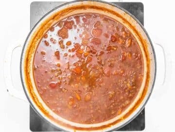Step 2 Adding lentils, tomatoes, and broth to the pot for simmering.