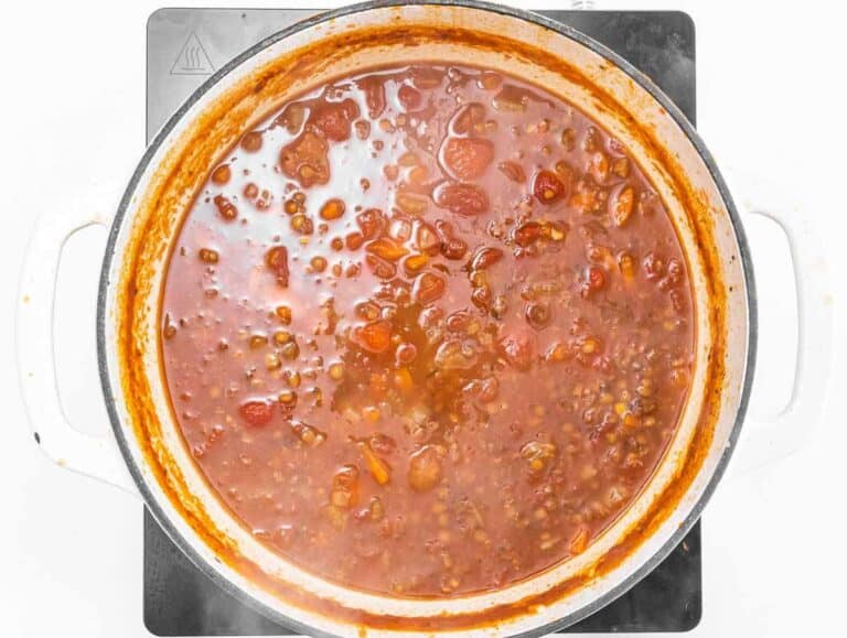 Step 2 Adding lentils, tomatoes, and broth to the pot for simmering.
