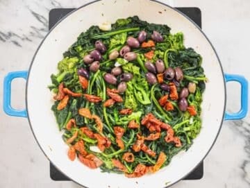 Step 2 Broccoli rabe cooking in a pan with sun-dried tomatoes and olives.