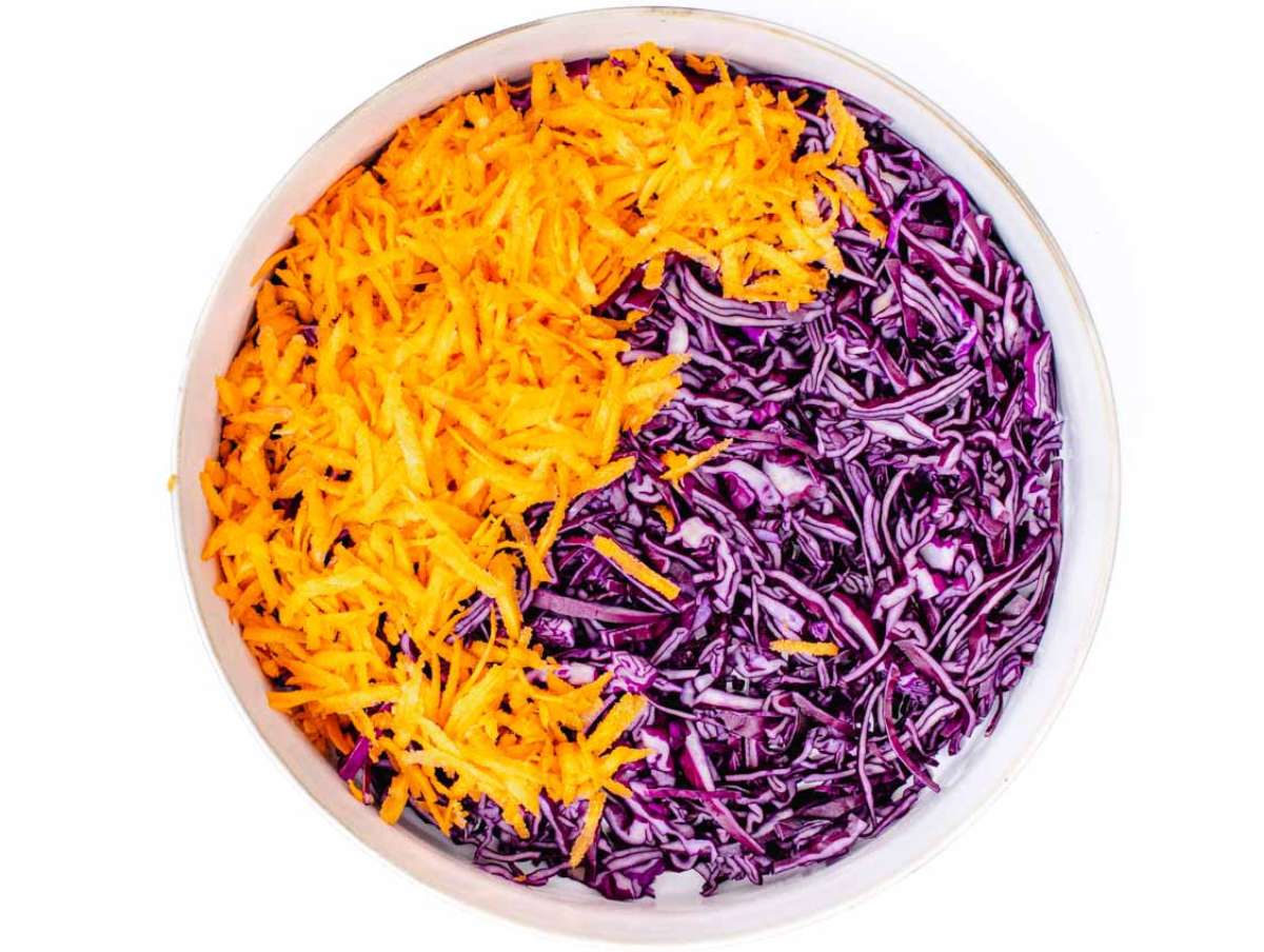 Step 2 Grated carrots and chopped parsley added to shredded cabbage for Greek Yogurt Cabbage Slaw.