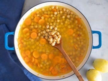 Step 2 Simmering chickpeas and broth in pot for creamy and hearty Greek chickpea soup.