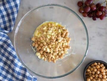 Step 2 Tossing chickpeas in honey feta dressing to marinate before mixing.