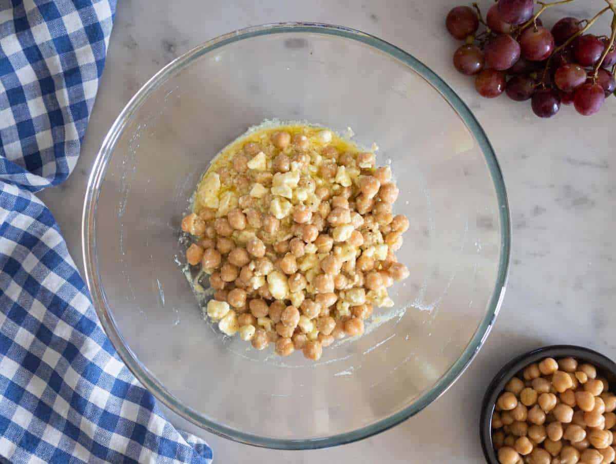 Step 2 Tossing chickpeas in honey feta dressing to marinate before mixing.