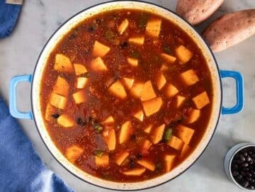 Step 2 image – Adding sweet potatoes, tomatoes, and black beans to the pot for black bean chili.