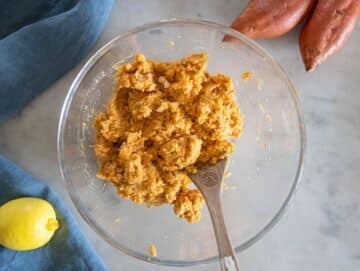 Step 2 – Adding onion, garlic, parmesan, and spices to mashed chickpea sweet potato mixture.