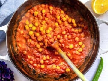 Step 3 Chickpeas and tomatoes simmering in skillet with broth for chickpea masala curry.