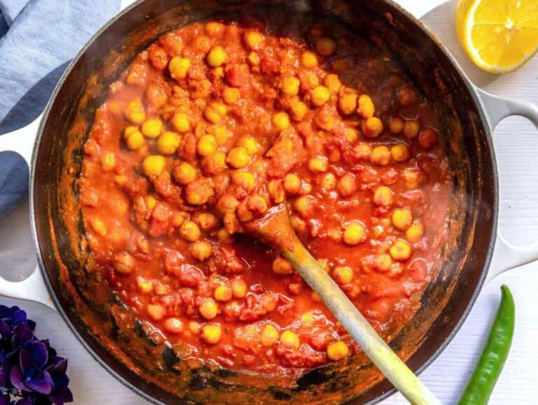 Step 3 Chickpeas and tomatoes simmering in skillet with broth for chickpea masala curry.