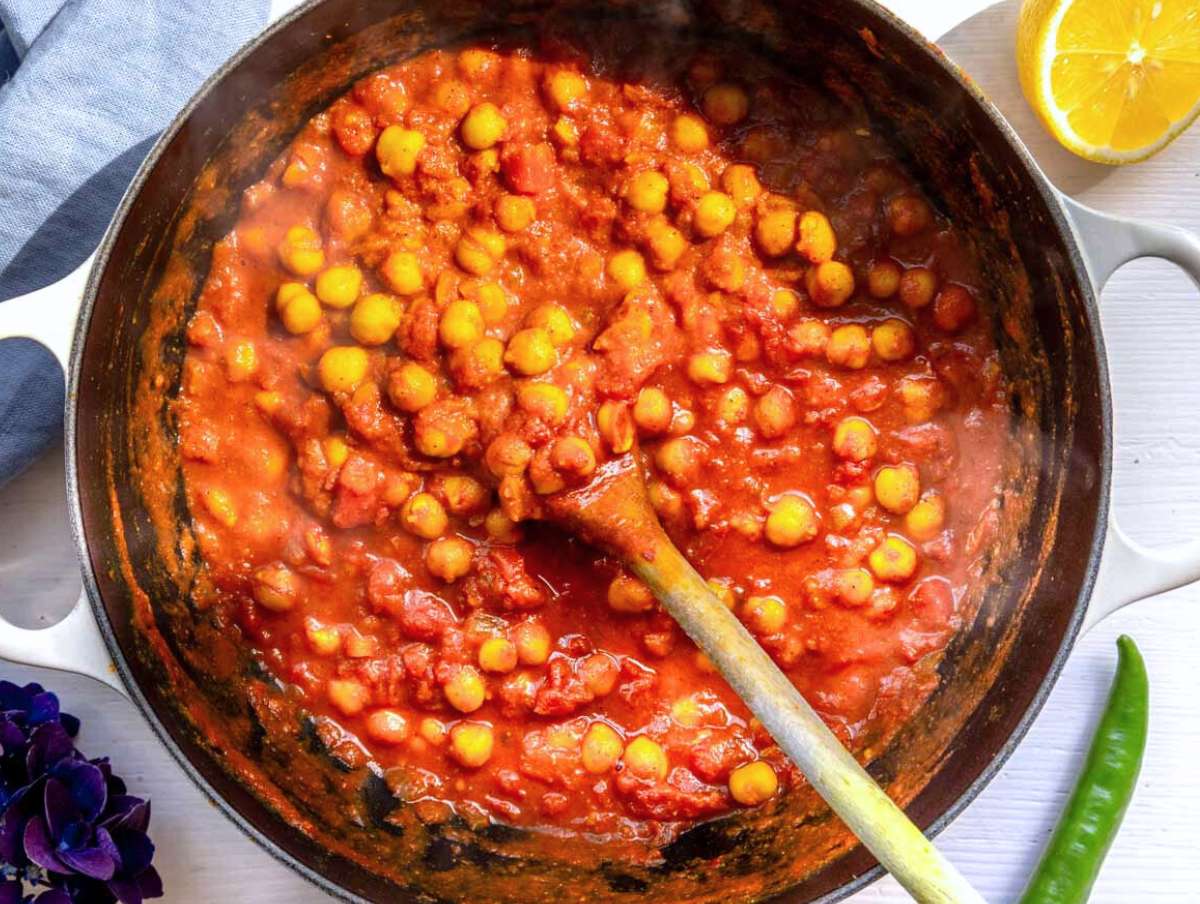 Step 3 Chickpeas and tomatoes simmering in skillet with broth for chickpea masala curry.