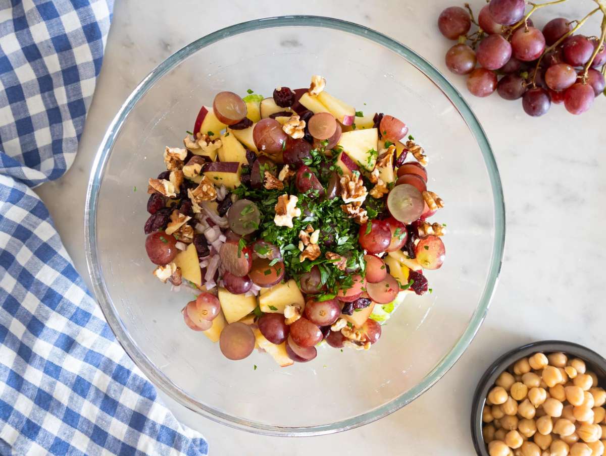 Step 3 Mixing chickpeas fruit and nuts in bowl for Mediterranean chickpea salad.